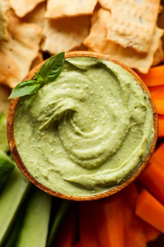 Creamy Basil Avocado Dip in a bowl with basil