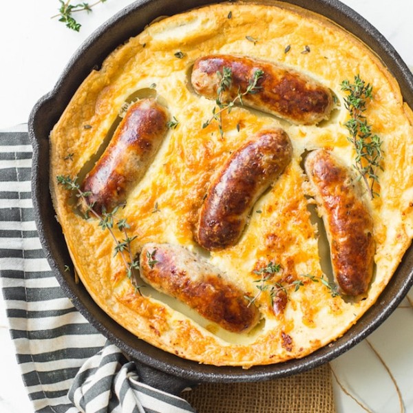 gluten free toad in the hole in a cast iron skillet topped with fresh thyme