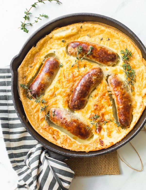 gluten free toad in the hole in a cast iron skillet topped with fresh thyme