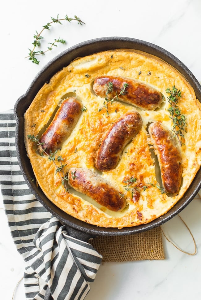 gluten free toad in the hole in a cast iron skillet topped with fresh thyme