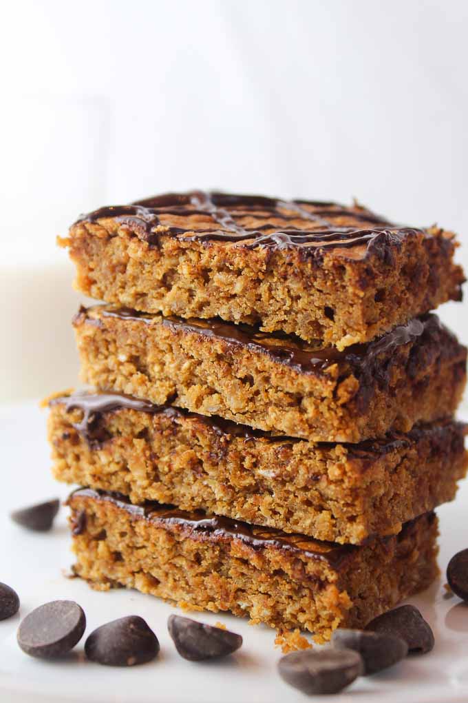 a stack of four Peanut Butter Oat Bars surrounded by chocolate chips