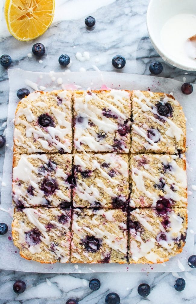 Sweet and chewy Blueberry Coconut Oat Square topped with a lemon glaze