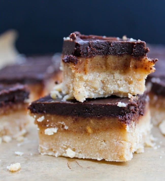 Vegan & Paleo Millionaire's Shortbread stacked on top of each of the with a bite taken out