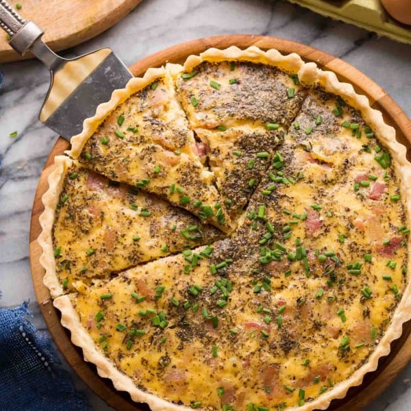 Dairy Free Quiche Lorraine (Low FODMAP) on a platter with slices cut out