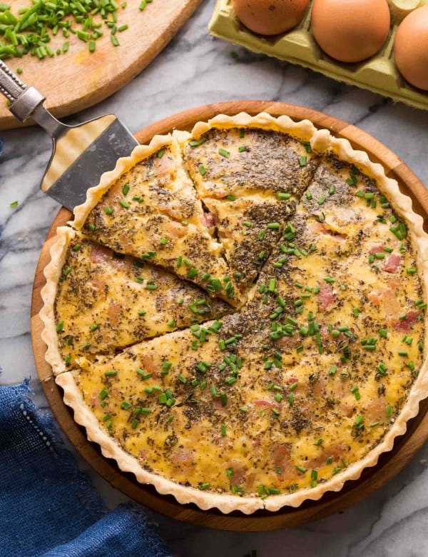 Dairy Free Quiche Lorraine (Low FODMAP) on a platter with slices cut out