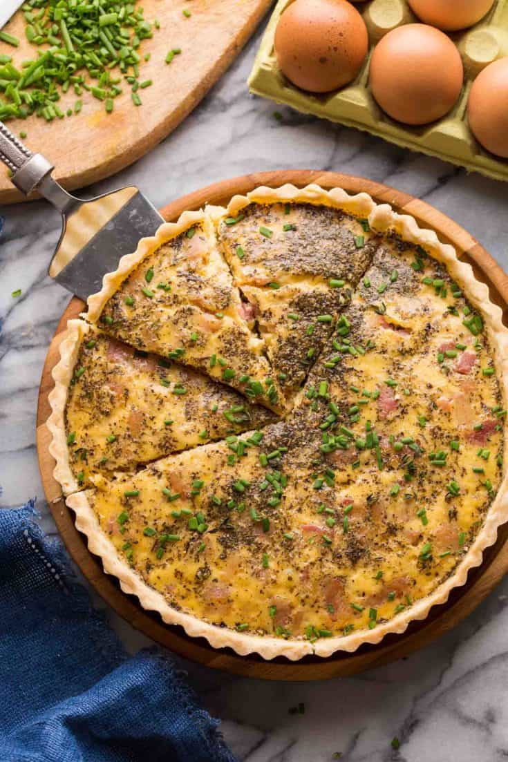 Dairy Free Quiche Lorraine (Low FODMAP) on a platter with slices cut out