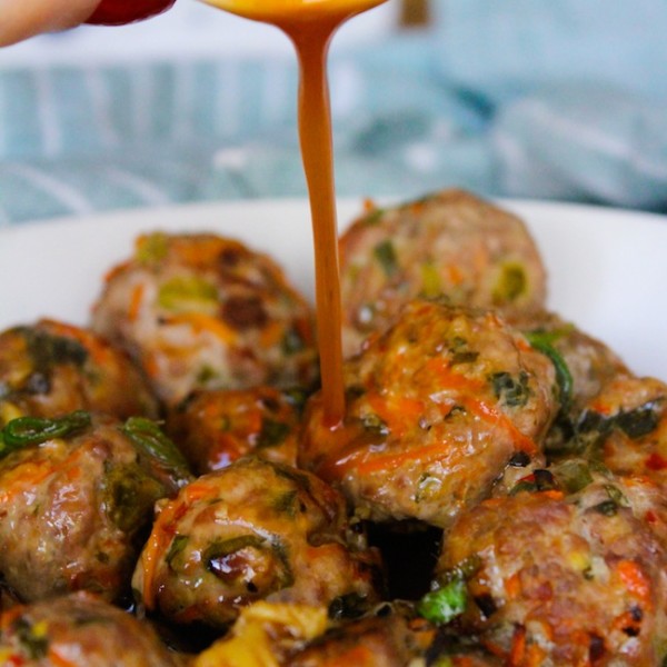 low fodmap thai meatballs in a ball with thai sauce pouring over the top