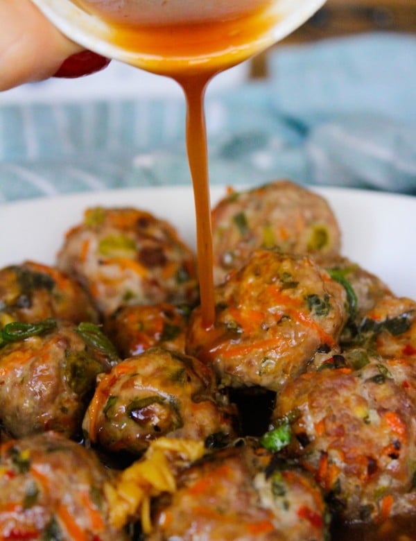 low fodmap thai meatballs in a ball with thai sauce pouring over the top