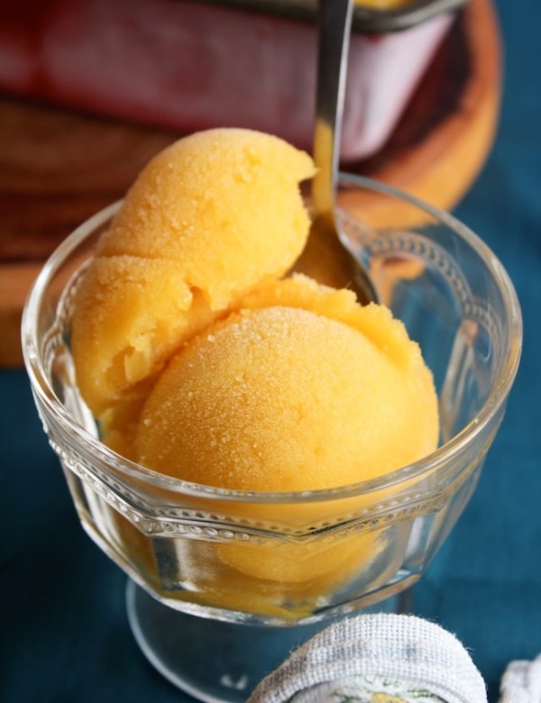 two scoops of pineapple mango sorbet in a serving glass
