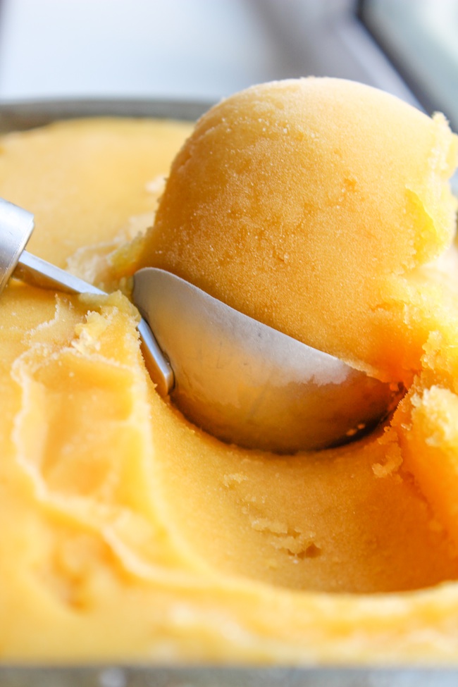 an ice cream scoop full of pineapple mango sorbet