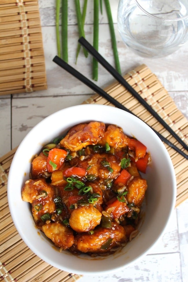 Paleo & Low FODMAP Sweet and Sour Chicken in a bowl with chop sticks 