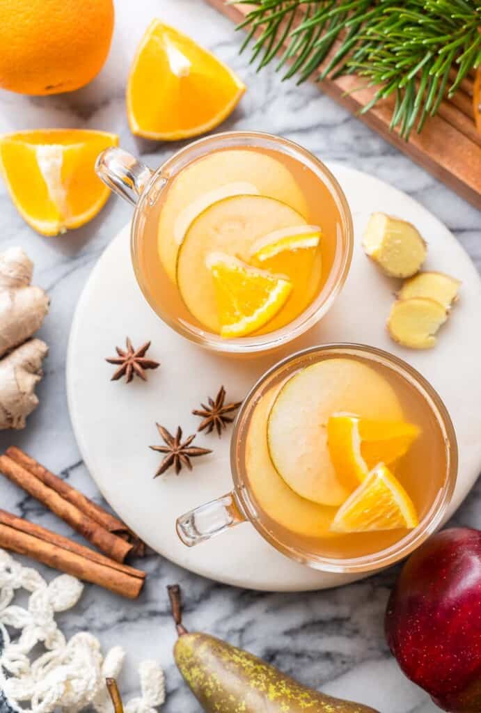 fruit slices inside mugs of apple pear cider