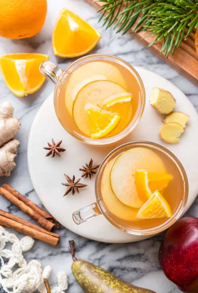 fruit slices inside  mugs of apple pear cider