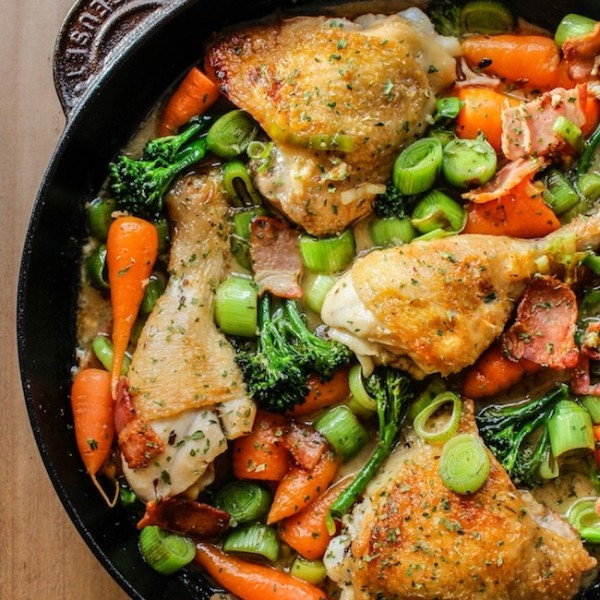 white wine braised chicken and veggies in a cast iron pan