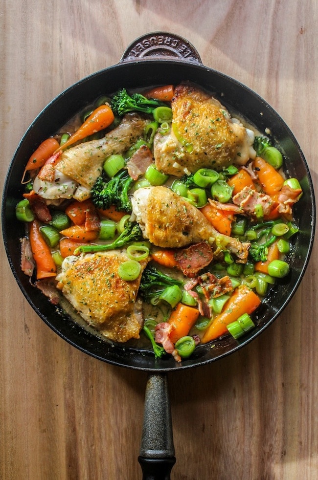 white wine braised chicken and veggies in a cast iron pan 