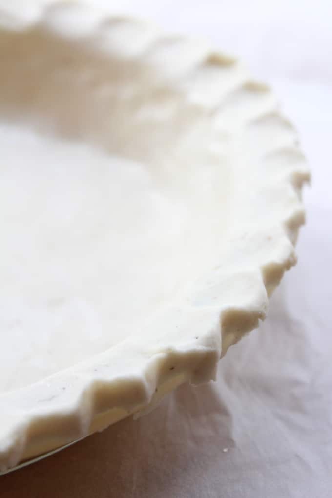 the edge of a crimped, unbaked coconut oil pie crust