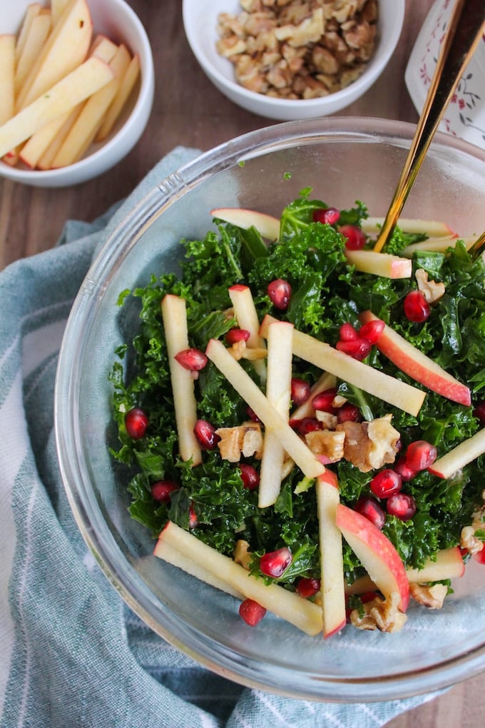 Kale Pomegranate Salad in a bowl with serving spoons
