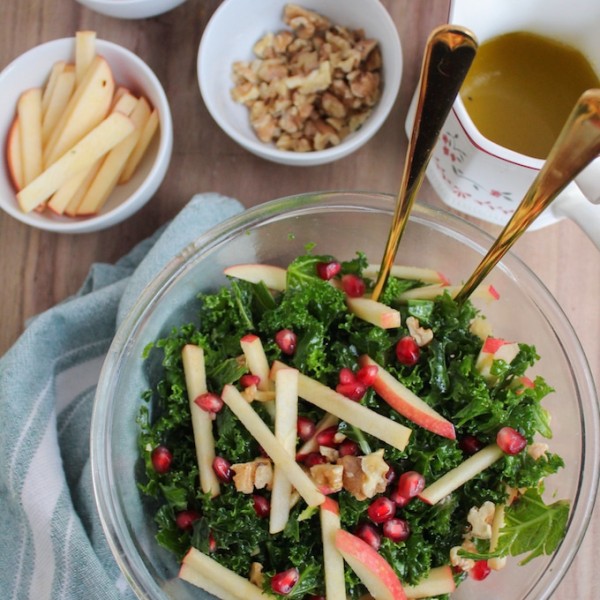 Winter Kale Pomegranate Salad: crisp apples, toasted walnuts, massaged kale and ruby red pomegranate seeds topped in a sweet and tangy honey mustard dressing.