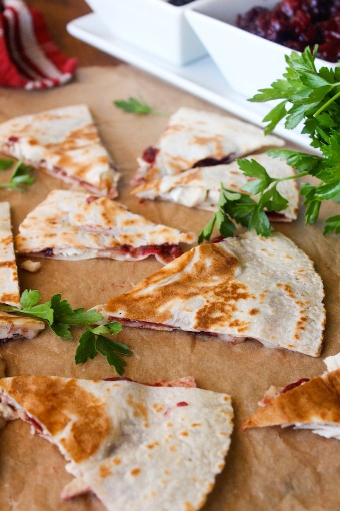 Turkey, cranberry, and brie quesadilla with a bowl of cranberry sauce