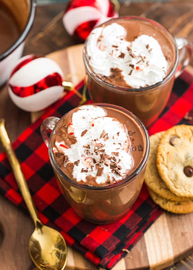 coconut milk peppermint hot chocolate topped with whipped cream and chocolate chip cookies on the side