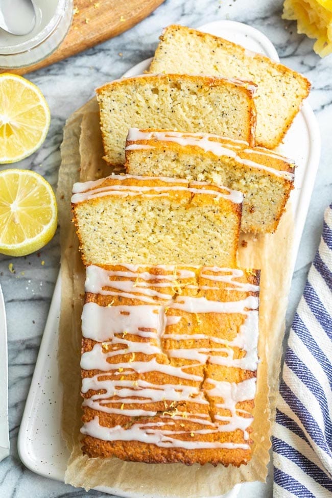 sliced almond lemon loaf on a platter with lemons 