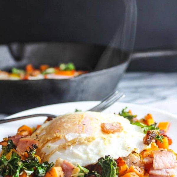 Bacon Kale & Sweet Potato Hash on a plate topped with steamy egg