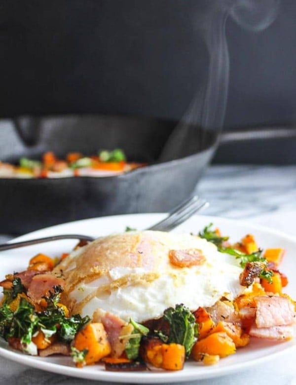 Bacon Kale & Sweet Potato Hash on a plate topped with steamy egg