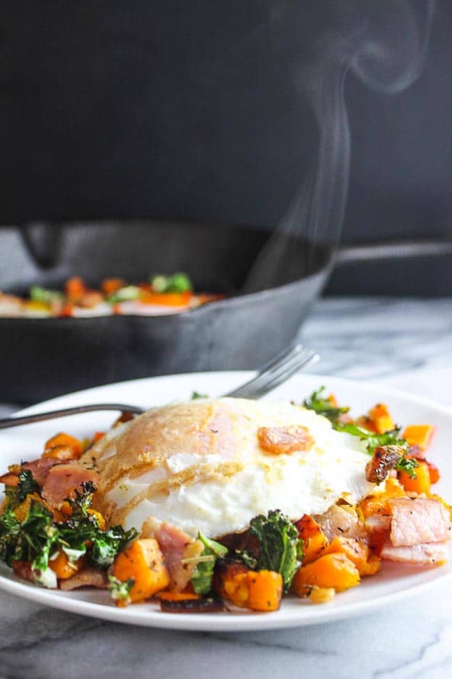 Bacon Kale & Sweet Potato Hash on a plate topped with steamy egg