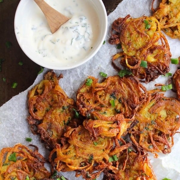 crispy onion bhajis on baking paper with a yoghurt dip