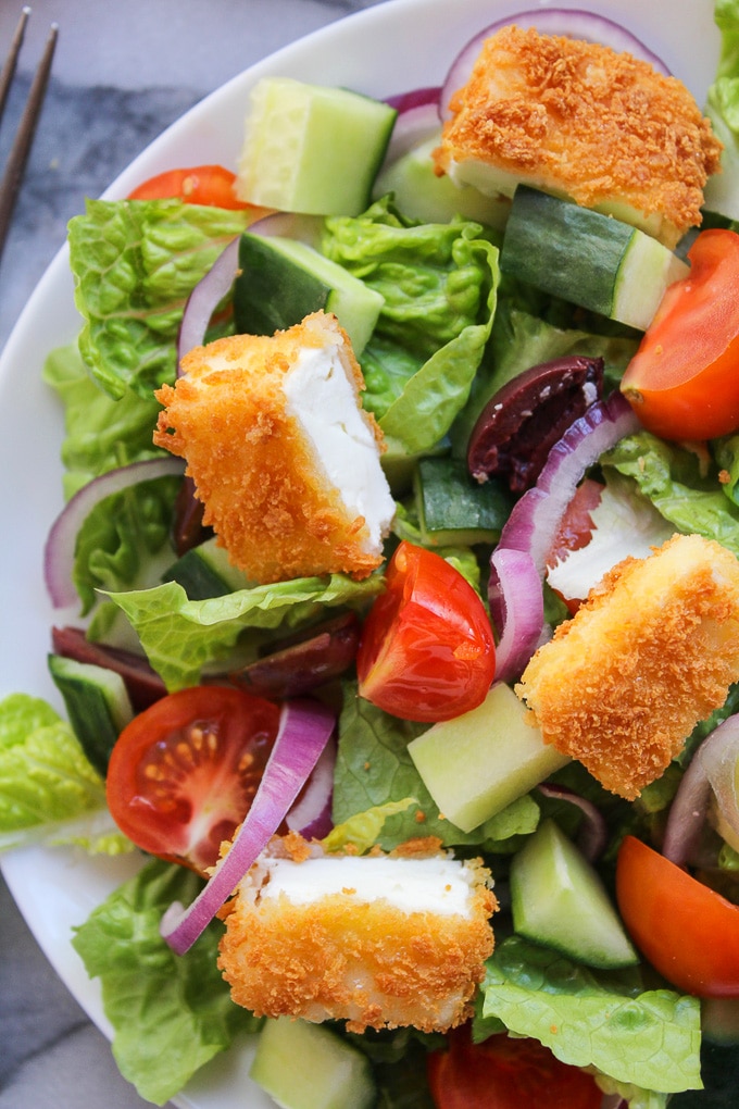 Crunchy Greek Salad topped with crispy fried feta coated in gluten free bread crumbs and dressed in a delicious red wine, lemon, and garlic herb vinaigrette 