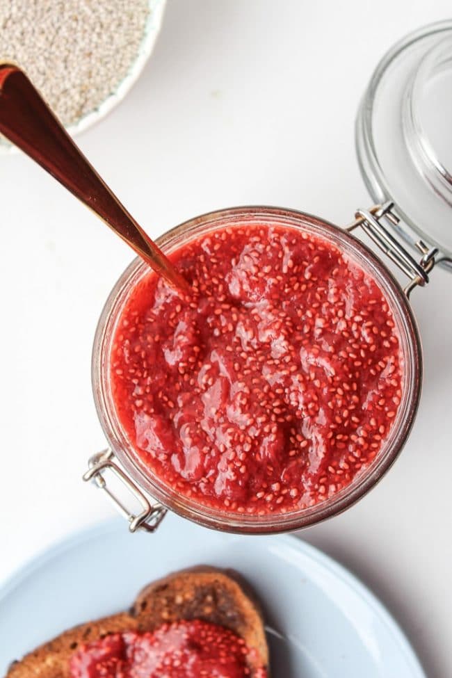 Homemade Chia Seed Jam in a jar with a piece of toast on the side