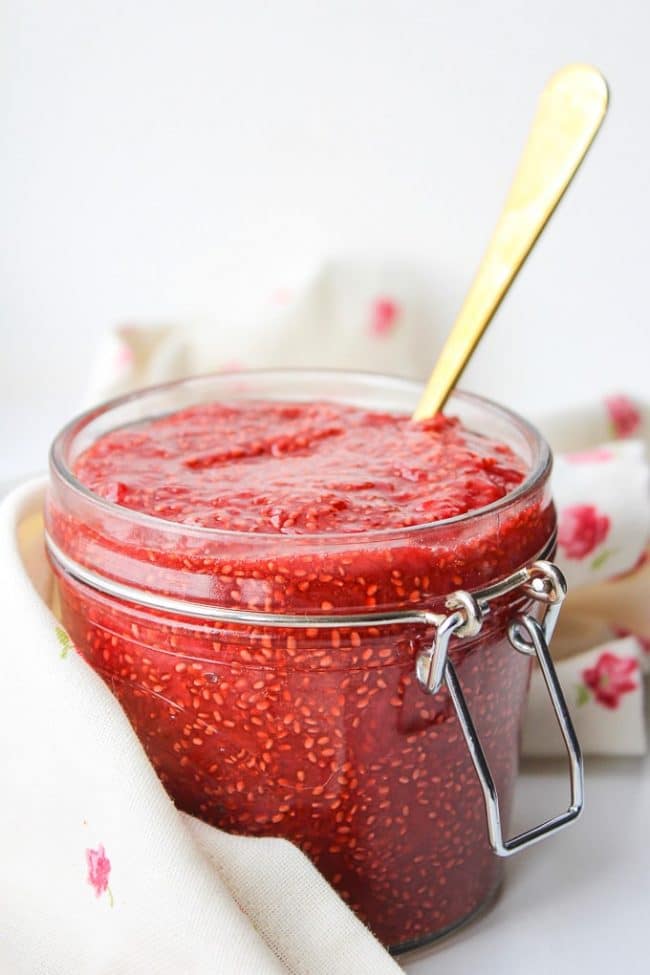 homemade chia seed jam in a jar with a gold spoon