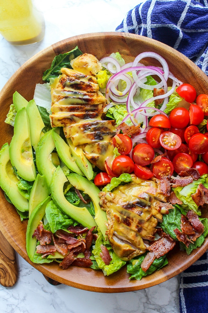 Honey Mustard Chicken Salad with bacon, avocado, sliced red onion, and sliced tomatoes topped with a three ingredient honey mustard dressing. Creamy, tangy and so addictive! Paleo & Dairy Free