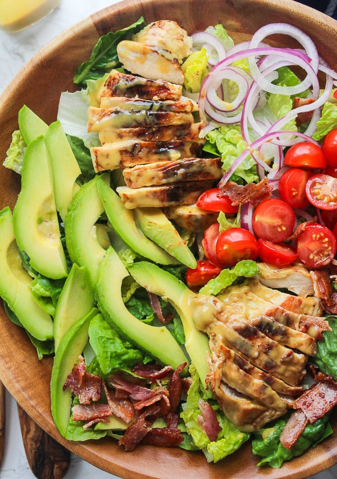 Honey Mustard Chicken Salad with bacon, avocado, sliced red onion, and sliced tomatoes topped with a three ingredient honey mustard dressing. Creamy, tangy and so addictive! Paleo & Dairy Free