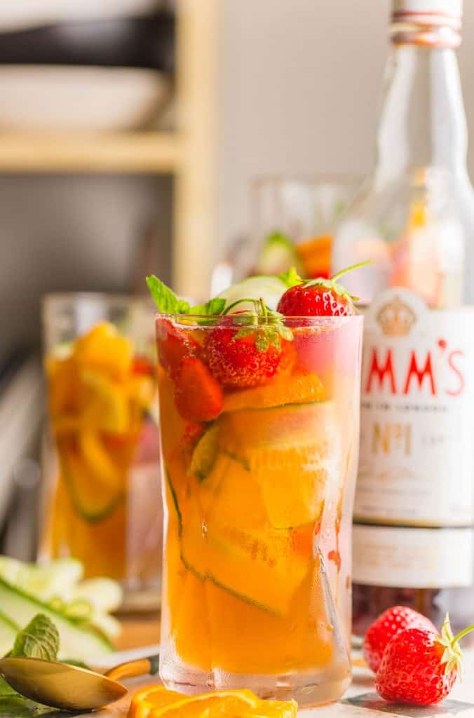 pimm's cup with fresh strawberries and cucumber in a glass