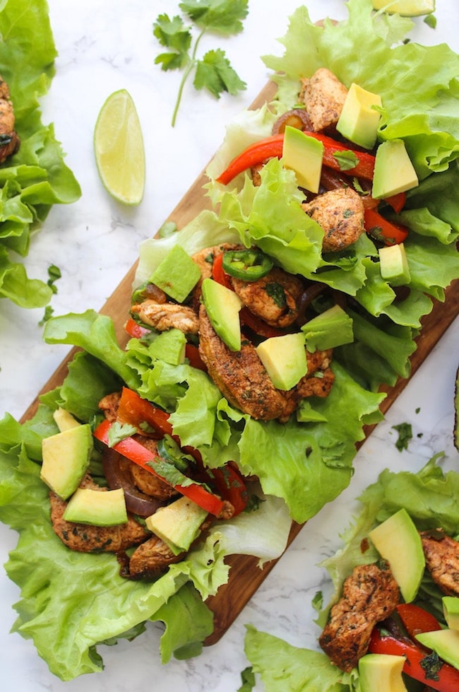 Easy Chicken Fajitas Lettuce Wraps with sautéed onions & peppers, seasoned chicken and topped with diced avocados 