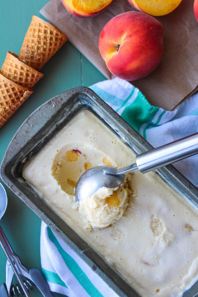 an ice cream scoop scooping up some coconut peach ice cream