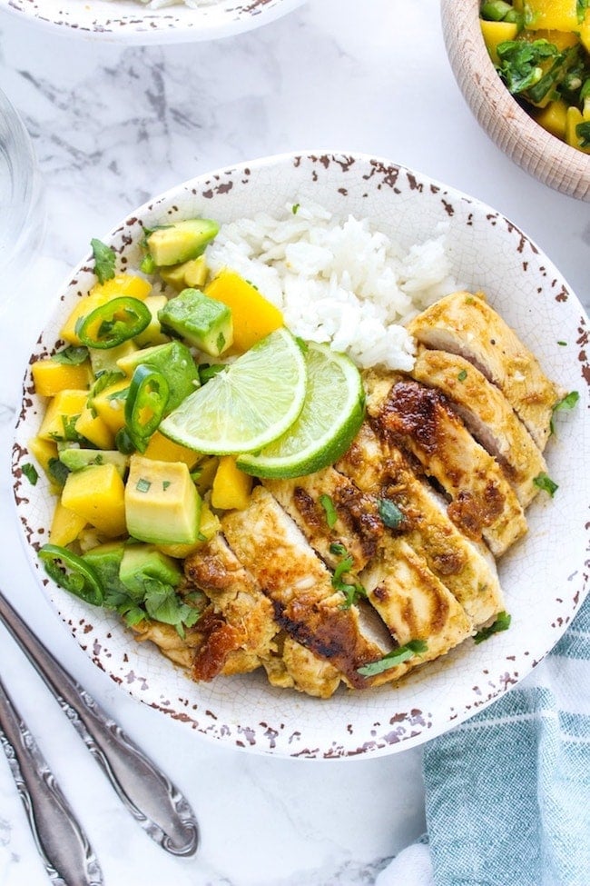 Whole 30 friendly Jerk Chicken in a bowl with rice and mango avocado salsa