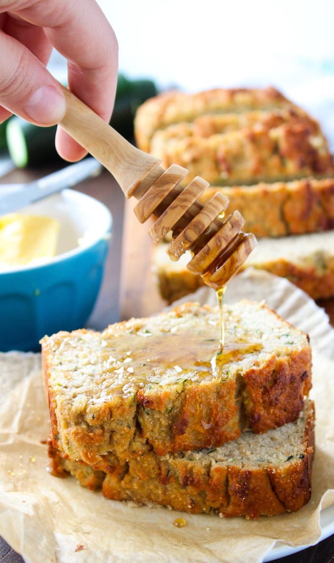 honey drizzling over the top of two Paleo Zucchini Bread slices