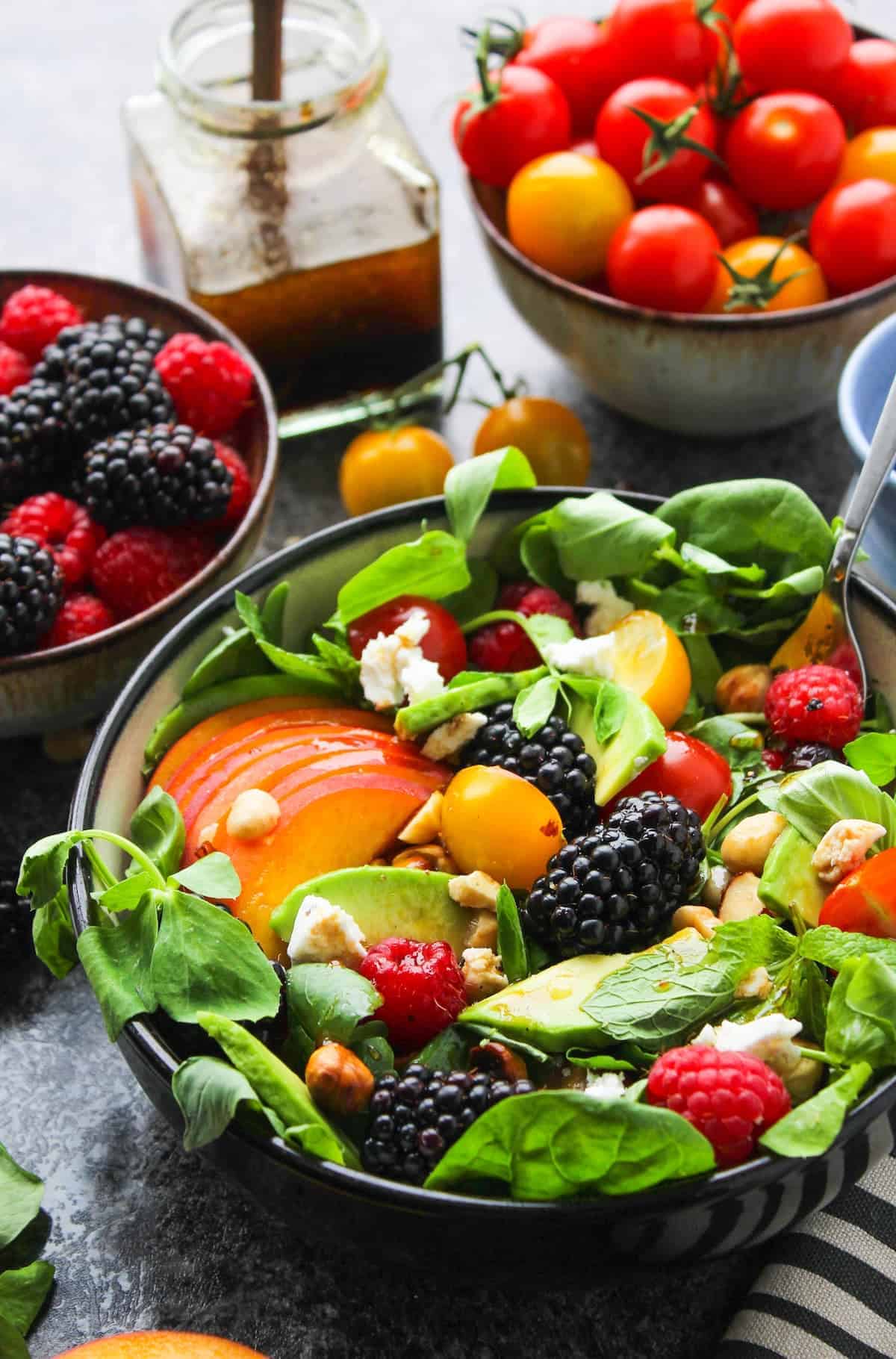 summer salad in a bowl with peach slices, blackberry and avocado