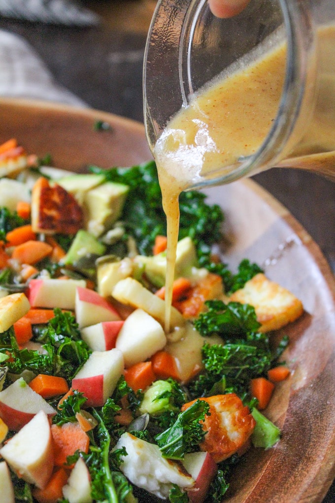 Crunchy Carrot Apple & Massaged Kale Salad topped with halloumi, avocado, seeds and a mustardy almond butter dressing | grain free + gluten free + vegetarian