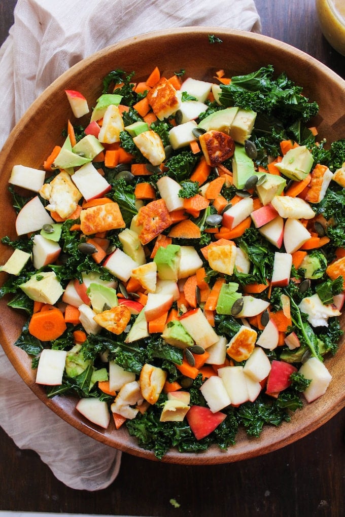 Crunchy Carrot Apple & Massaged Kale Salad topped with halloumi, avocado, seeds and a mustardy almond butter dressing | grain free + gluten free + vegetarian