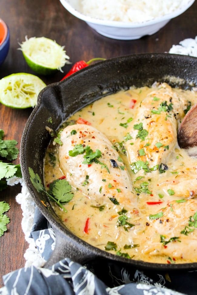 Coconut Lime Chicken in a cast iron skillet with a wooden spoon