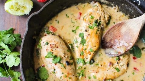 coconut lime chicken in a skillet topped with fresh cilantro