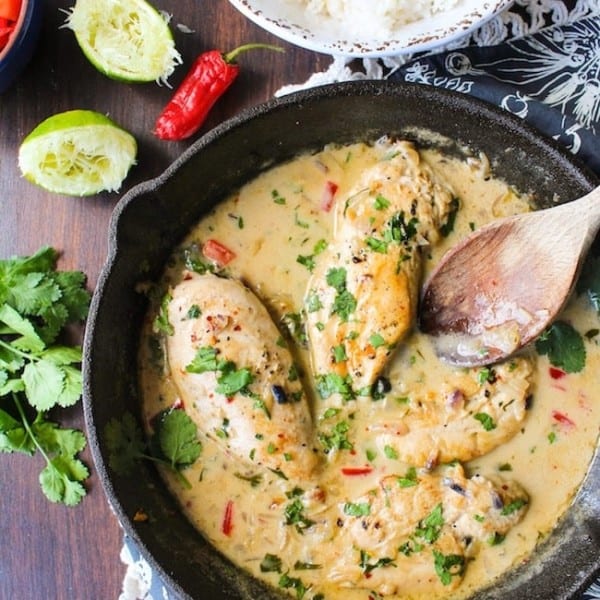 coconut lime chicken in a skillet topped with fresh cilantro