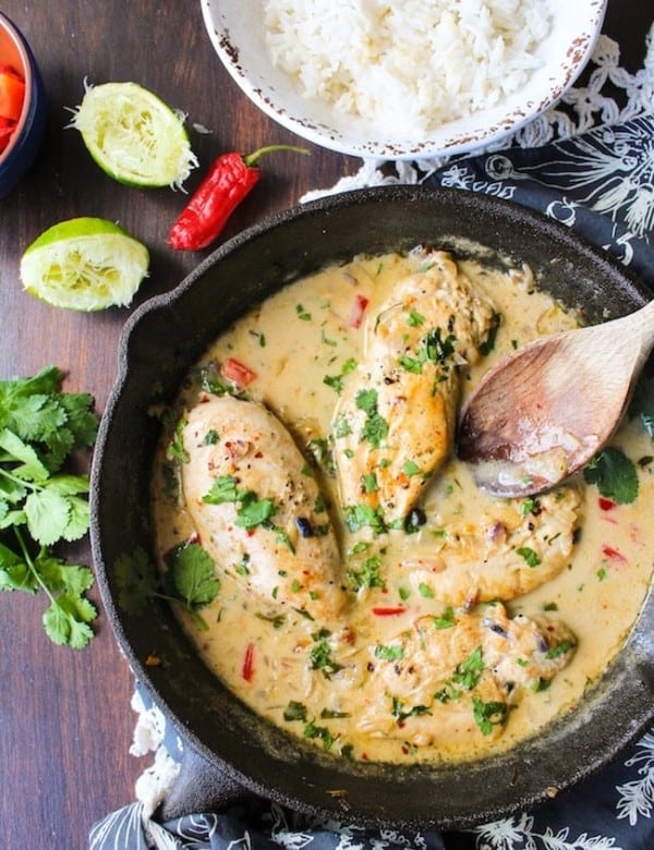 coconut lime chicken in a skillet topped with fresh cilantro