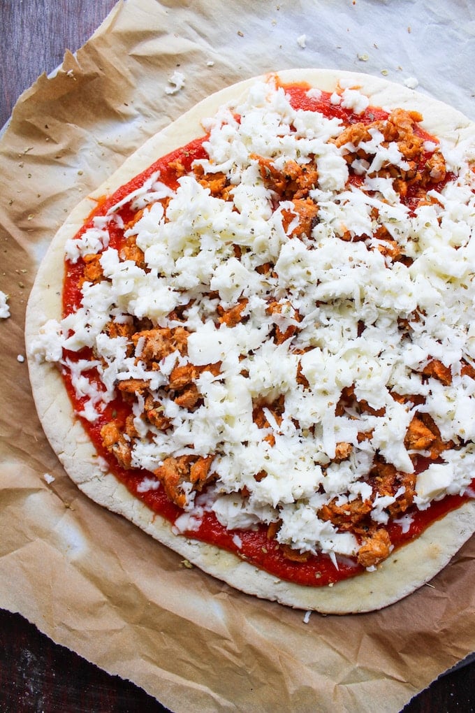 A simple gluten free pizza crust recipe topped with mozzarella cheese, chorizo sausage and fresh herbs