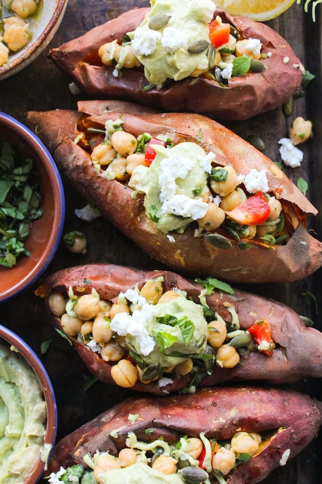 Mediterranean stuffed sweet potatoes with marinated chickpeas and topped with an avocado tahini sauce 