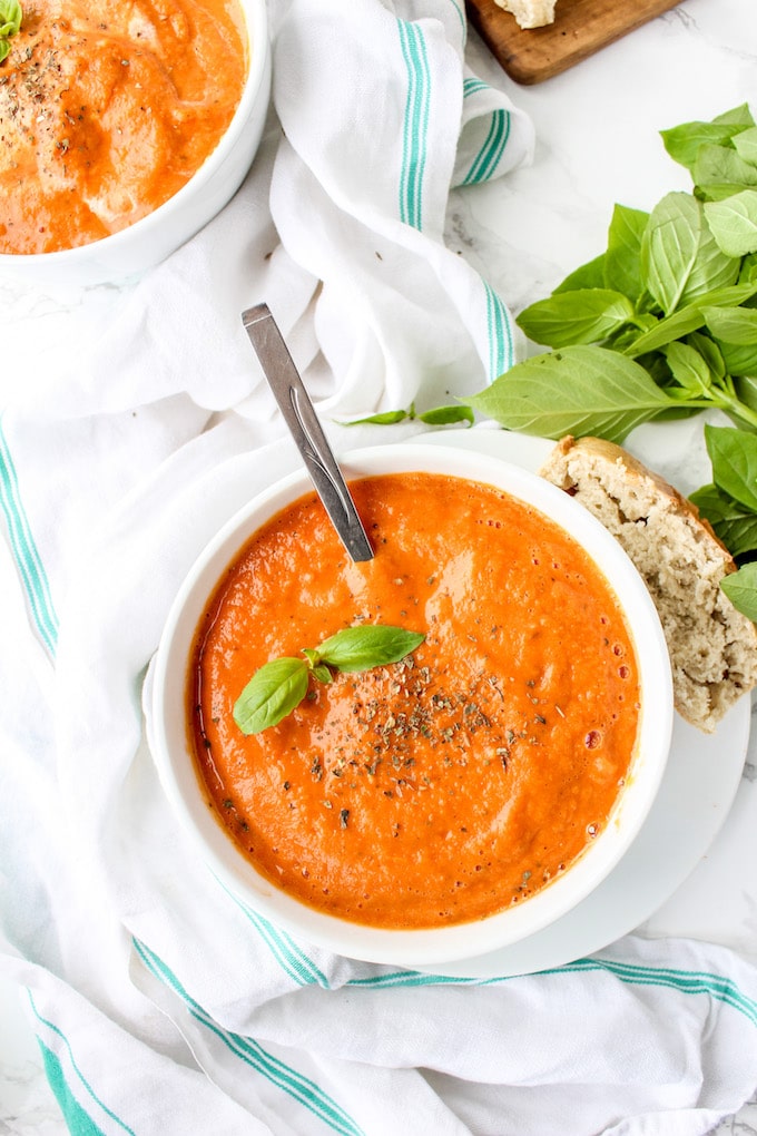 Creamy Roasted Tomato Soup - a fuss free, cool weather comfort. Serve alongside a loaf of crusty French bread and top with fresh basil | paleo + vegan 