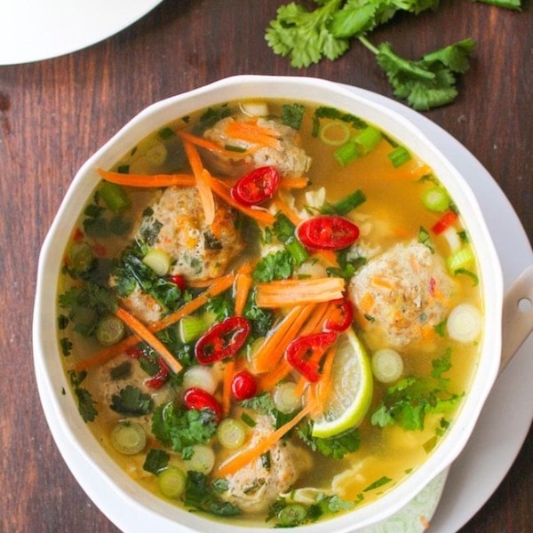 Thai-Meatball-Soup in a white bowl surrounded by cilantro